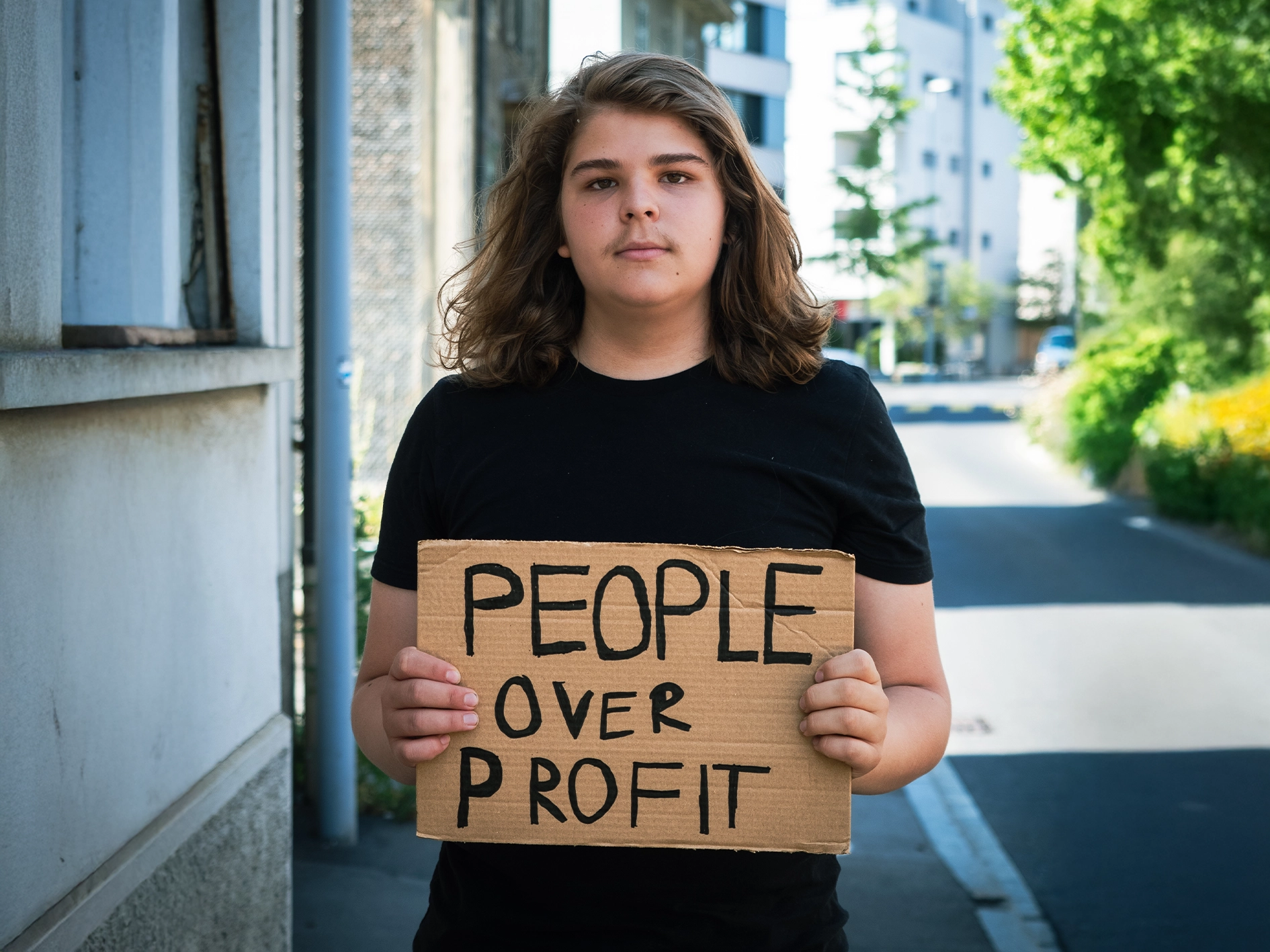 Politischer Aktivist Simeo Betschart hält ein Protestschild im urbanen Stadtraum von Zug